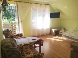 a living room with a table and a bed and a window at Apartament 2pokojowy 4-5osobowy in Węgorzewo