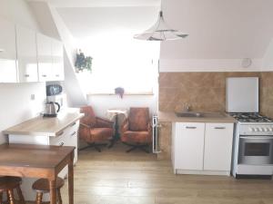 a kitchen with a stove and a table and chairs at Apartament 2pokojowy 4-5osobowy in Węgorzewo
