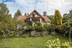 een huis op een heuvel met een stenen muur bij Jaworowy Stok z widokiem na góry i ogrodem in Jugów