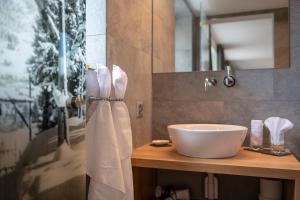 a bathroom with a white sink and a mirror at Berghotel Tgantieni in Lenzerheide