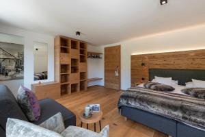 倫策海德的住宿－Berghotel Tgantieni，一间卧室配有一张大床和一张沙发