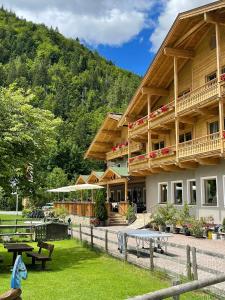 a building with picnic tables in front of it at Landhotel Strasserwirt in Sankt Ulrich am Pillersee