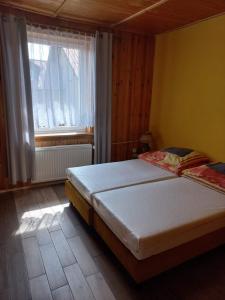 1 dormitorio con 2 camas y ventana en Holiday Ozon, en Sztutowo