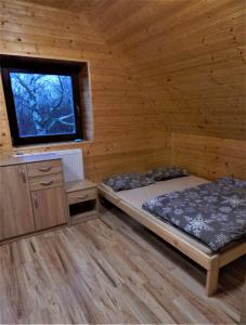 um quarto com uma cama e uma janela num camarote em ROUBENKA-JESENKA II em Dolní Moravice