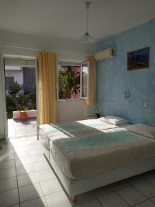 a bedroom with a large bed and a window at Livadi Apartments in Plakias