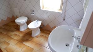 een badkamer met een toilet en een wastafel bij Ginepro in San Vito