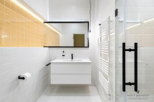 uma casa de banho branca com um lavatório e um espelho em White Boat Studio Apartment GOLD em Budapeste