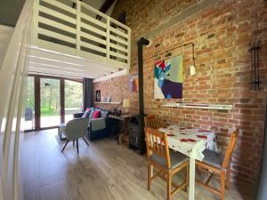 a living room with a table and a brick wall at Ostoja Miłolas in Lidzbark Warmiński