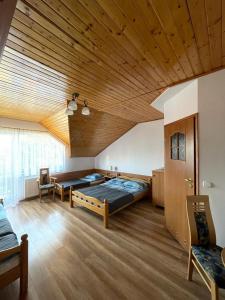 een slaapkamer met 2 bedden en een houten plafond bij ASIA- Pokoje Gościnne i Studia in Ostrowo