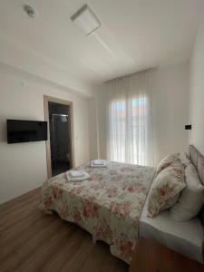 a bedroom with a bed and a television in it at Adil Pansiyon in Cesme