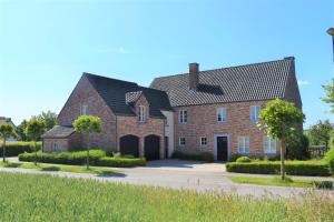 a large red brick house with a driveway at Le Verger du Patagon in Rofessart