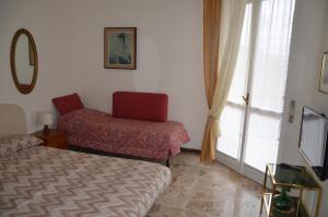 sypialnia z łóżkiem, krzesłem i oknem w obiekcie Bellavista Romeo Apartments w Como