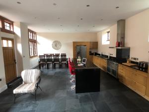 a large kitchen with a counter and chairs in it at The Stables in Frizington