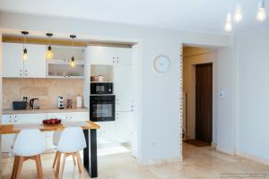a kitchen with a wooden table and white cabinets at Alpine Luxury Apartment Arinis in Gura Humorului +17 photos