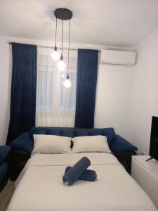 - une chambre avec un lit à tête bleue dans l'établissement Apartman Stella Maris, à Ljubuški