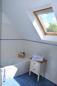 a bathroom with a bath tub and a window at Le Verger du Patagon in Rofessart