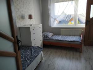 オストロボにあるAPARTAMENT Ostrowoの小さなベッドルーム(ベッド2台、窓付)