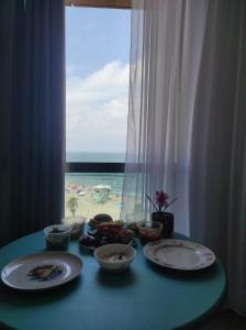 een tafel met borden en uitzicht op het strand bij maytoro in Haifa