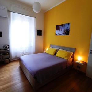 a bedroom with a bed and a yellow wall at Colazione da Augusta - Guesthouse in Turin