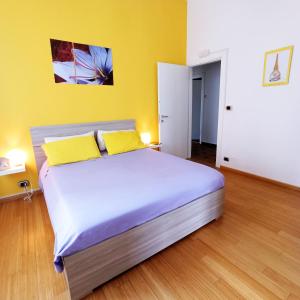 a bed with two yellow pillows in a room at Colazione da Augusta - Guesthouse in Turin