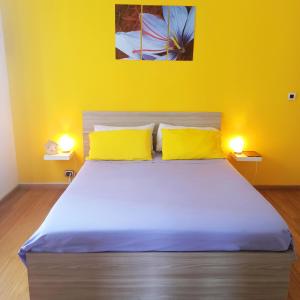 a bedroom with a large bed with two yellow pillows at Colazione da Augusta - Guesthouse in Turin