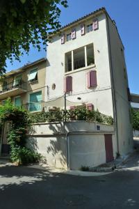 un edificio blanco con balcones en un lateral en Chez Berni en Millau