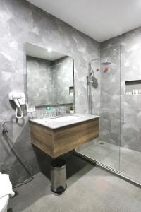 y baño con lavabo y ducha. en Carlosta Hotel, en Ormoc