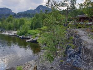 a river with a house on the side of it at Holiday Raustua Cabin in Gol