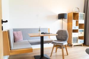 Camera con divano, scrivania e sedia. di Ferienwohnung Magdalena - Fritz Apartments a Innsbruck