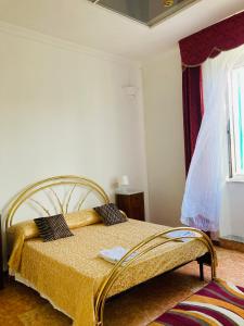 ein Schlafzimmer mit einem Bett mit einer gelben Decke und einem Fenster in der Unterkunft La Loggia di Ischia in Ischia di Castro