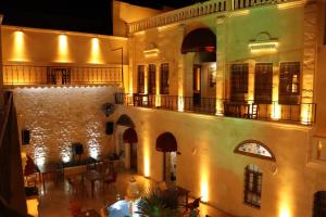 an old building with a balcony and a courtyard at BABIL ANTIQUE HOTEL in Sanlıurfa
