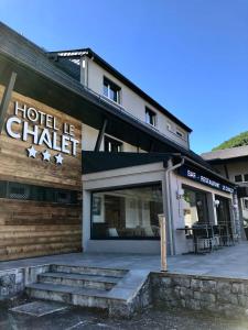 ein Hotelgebäude mit einer Treppe davor in der Unterkunft Hotel Le Chalet in Sainte-Marie-de-Campan