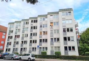 an apartment building with cars parked in front of it at Apartment am Stadtbach by Aux Property in Augsburg