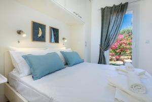 a bedroom with a large white bed with blue pillows at VILLA HELIODORE in Astris