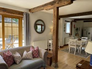 a living room with a couch and a table at Spacious Cotswold country cottage in Buscot