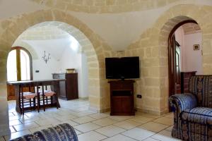 a living room with a tv and a table and chairs at Trulli Monte Madre in San Vito dei Normanni