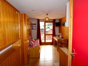 a living room with a red door and a table at Charmant T2 cabine 4 pers, centre-village, proche pistes et commerces, balcon sud, piscine l'été - FR-1-342-145 in Arêches