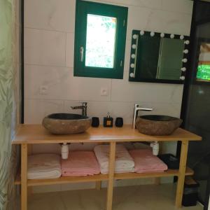 ein Badezimmer mit zwei Waschbecken auf einem Holztisch in der Unterkunft Le château des fées in Illoud
