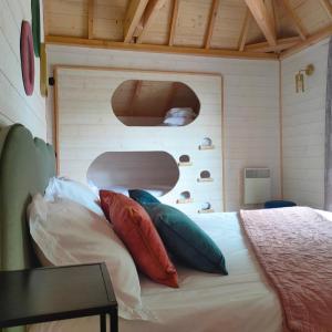 ein Schlafzimmer mit einem Bett mit Kissen darauf in der Unterkunft Le château des fées in Illoud