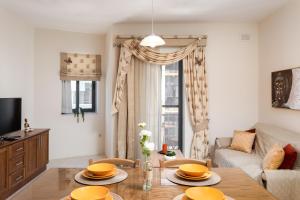 a living room with a table and a couch at Spacious, Bright & Cosy 2 Bedroom 2 Bathroom Apartment - Msida Uni Heights in Msida