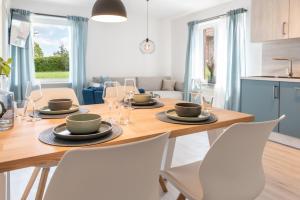 a kitchen and dining room with a wooden table and chairs at Strandperle Appartements in Hasselberg