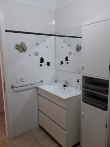 a white bathroom with a sink and a mirror at Departamento Joelle in Puerto del Carmen