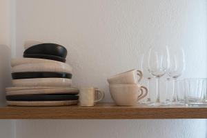 a shelf with plates and wine glasses on it at Paris Studios & Apartment in Agia Paraskevi
