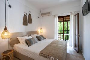 a bedroom with a bed and a balcony at Paris Studios & Apartment in Agia Paraskevi