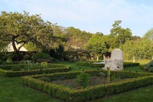 un jardín con una estatua en el medio en MAISON DANS LE CHARMANT VILLAGE DE LA VRAIE-CROIX, en La Vraie-Croix