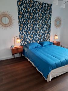 una camera con letto blu e testiera blu di Le soleil Dunkerquois a Dunkerque