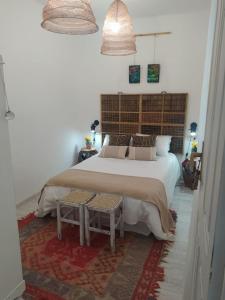 1 dormitorio con 1 cama blanca grande y 2 mesas en Piso Iwvaxi, gallery house. Ourense., en Ourense