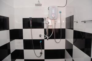 un bagno con doccia e piastrelle bianche e nere di Concey Transit Hotel Airport view a Katunayake
