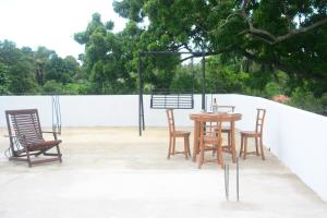 Une table et des chaises en bois sont disponibles sur la terrasse. dans l'établissement Concey Transit Hotel Airport view, à Katunayake