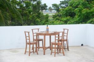 een tafel met vier stoelen en een fles wijn bij Concey Transit Hotel Airport view in Katunayaka